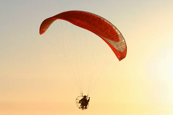 Una spiaggia al tramonto e un volo con il paramotore per un'esperienza emozionante